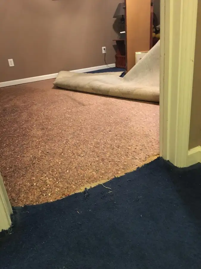Carpet pad removal revealing water damage during Water Mitigation Services in McKinney